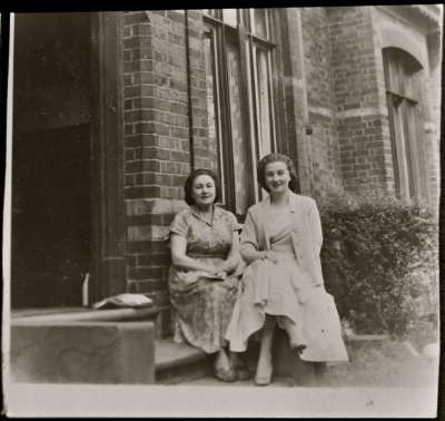 Portrait of two women outside a house